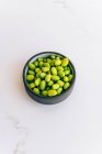 Green peas in a bowl on a white background — Stock Photo