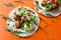 Wraps with spicy meatballs, cucumber and rocket — Stock Photo