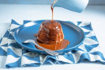Hot toffee pudding with toffee sauce poured — Stock Photo