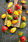 Tomates coloridos em uma superfície rústica — Fotografia de Stock