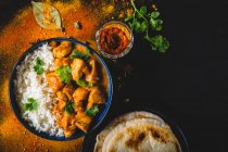 Indian Butter chicken with basmati rice in bowl, spices, naan bread — Stock Photo