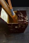 Uma caixa de seda oriental com um tapete de bambu e pauzinhos — Fotografia de Stock