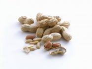 Amendoins com e sem conchas sobre um fundo branco — Fotografia de Stock