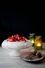 Pavlova with fresh strawberries and blueberries served on stand — Stock Photo