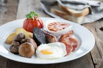 Englisches Frühstück auf weißem Teller mit weißem Scheibenbrot auf Hintergrund — Stockfoto