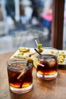 Cocktail alcolico con ghiaccio e limone su un tavolo di legno — Foto stock