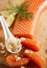 Smoked salmon fillet on a wooden board with horseradish - foto de stock