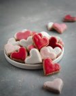 Biscotti al cuore rosa, rossi e bianchi sul piatto — Foto stock