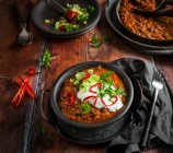 Vegetarian Chilli with yoghurt spring onion slices of chilli and parsley topping — Stock Photo