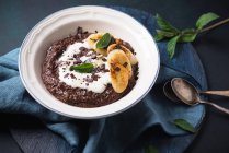 Vegan chocolate semolina porridge with soy yogurt, fried banana and mint — Stock Photo