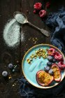 Un tazón de batido azul vegano con espirulina, frutas y nueces - foto de stock