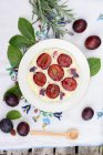 Rice pudding with plums and lavender flowers — Stock Photo