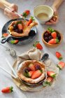 Holländische Baby-Pfannkuchen mit Erdbeeren und Brombeeren Kaffeetasse Hände — Stockfoto