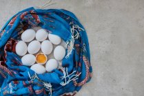 Huevos blancos envueltos en pañuelo azul - foto de stock