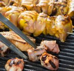 Dates in bacon and meat kebabs on a barbecue — Photo de stock