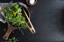 Purslane and edible flowers in a wooden bowl — Stock Photo