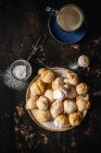 Mini rosquillas con azúcar en polvo y una taza de café - foto de stock