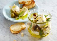 Pickled creamy Camembert with olives, onion and sage served with grilled baguette — Stock Photo
