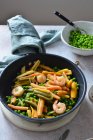 Colorful pasta with shrimps and green peas in white wine sauce — Stock Photo