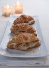Delizioso croissant con formaggio e burro su piatto bianco — Foto stock