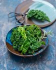 Fresh green spinach leaves in a bowl on a wooden background. top view. — Stock Photo