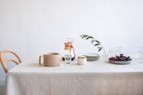 Красивий білий стіл з кавою і чашкою чаю на дерев'яному фоні — стокове фото
