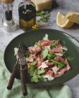 Veal carpaccio with arugula and parmesan cheese — Stock Photo
