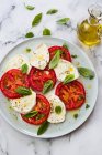 Caprese-Salat mit Mozzarella, Tomaten, Basilikum und Käse. auf weißem Hintergrund. — Stockfoto