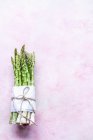 Куча зеленой спаржи на розовом фоне — стоковое фото