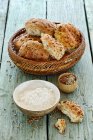 Rolos em uma cesta de pão com farinha e sementes — Fotografia de Stock