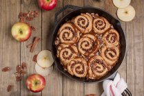 Яблучні клейкі булочки з карамельним соусом на чавунній сковороді — стокове фото