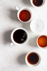 Kaffeetassen, auf verschiedenen Ebenen gefüllt — Stockfoto