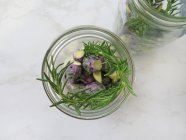Purple Brussels sprouts in two jars to be pickled with rosemary — Stock Photo