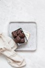 Chocolate candy with nuts and dates in gift box on white marble background — Photo de stock