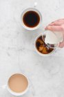 Trois tasses à café avec café et lait — Photo de stock
