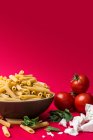 Ein Arrangement aus Penne-Nudeln, Tomaten, Käse und Kräutern — Stockfoto