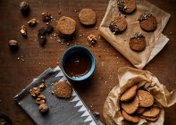 Горіхове печиво занурене в розтоплений шоколад і посипане подрібненими волоськими горіхами — стокове фото