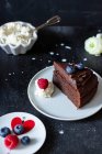 Una fetta di torta al cioccolato con ganache e bacche fresche — Foto stock