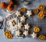 Biscoitos de estrelas com açúcar de confeiteiro e fatias de laranja secas — Fotografia de Stock