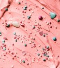 Crema de mantequilla rosa con perlas de colores y corazones - foto de stock