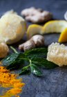 Лимон, імбир, порошок куркуми, медонос і м'ята на синій поверхні — стокове фото