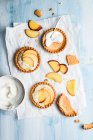 Tartlets with whipped cream and peaches, top view — Stock Photo