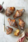 Homemade croissants on a cooling rack with jam — Stock Photo