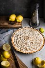 Безе пирог с лимонами, теркой и ножом — стоковое фото