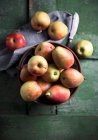 Pommes et poires dans un bol sur une surface en bois vert — Photo de stock