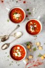 Enamel cups with smoky tomato soup topped with feta and herbs — Stock Photo
