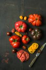 Tomates frescos e manjericão sobre um fundo preto — Fotografia de Stock