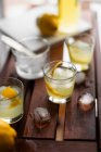 Limoncello with ice cubes and fresh lemon peel — Stock Photo