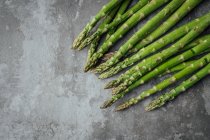 Green asparagus on cement background — Stock Photo