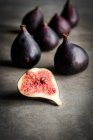 Fresh figs, whole and half on rustic table surface — Stock Photo